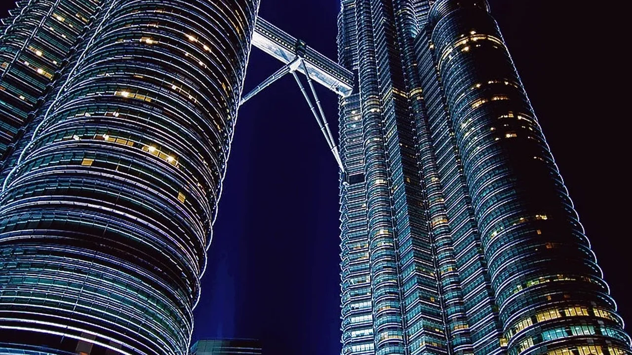 The Petronas Twin Towers and skybridge lit up at night in Malaysia